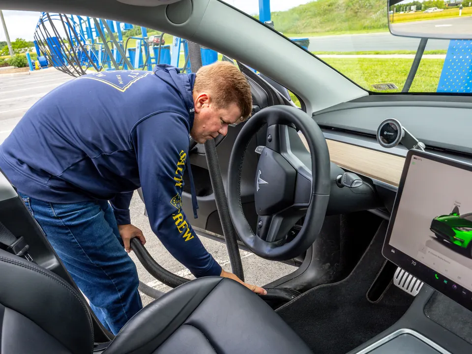 Woodstock Car Wash attendant vacuuming a car interior